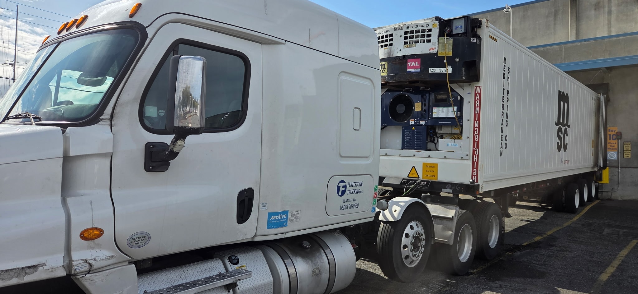 Flintstone Trucking truck with a refrigerated container at a loading dock